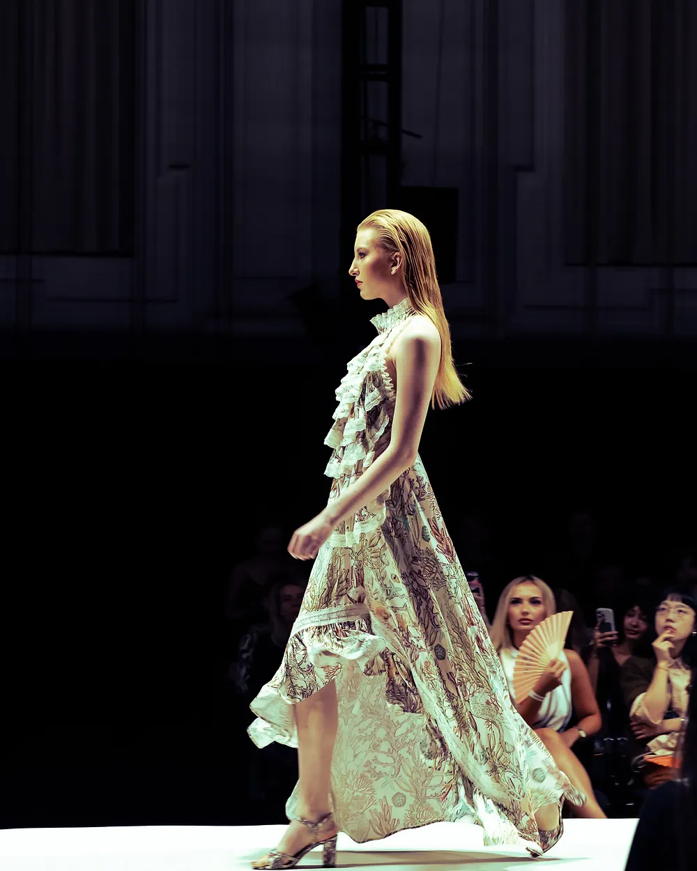 Model in einem hellgrünen Kleid mit floralen Applikationen