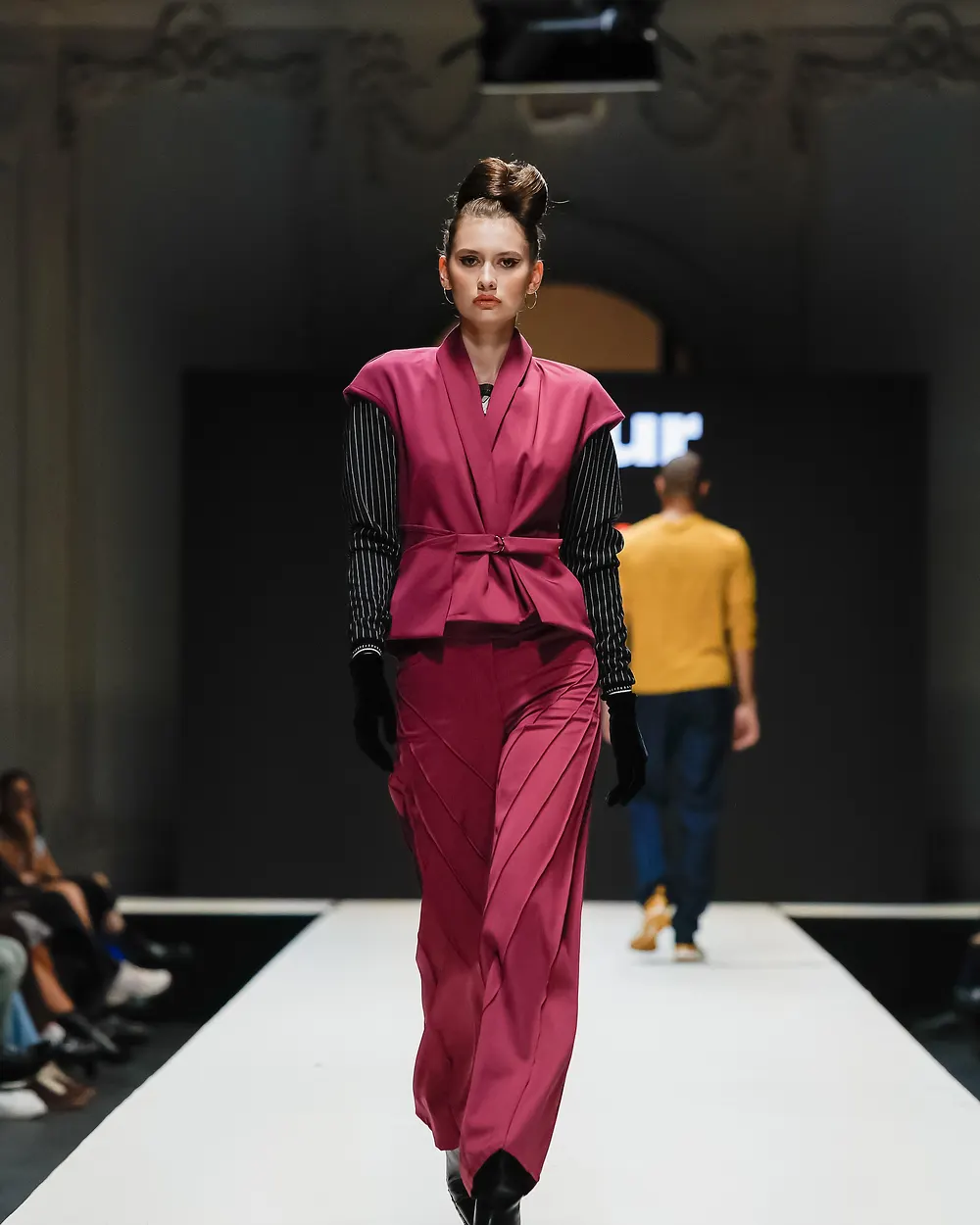 Model in beerenfarbenem Ensemble mit kontrastierenden Ärmeln