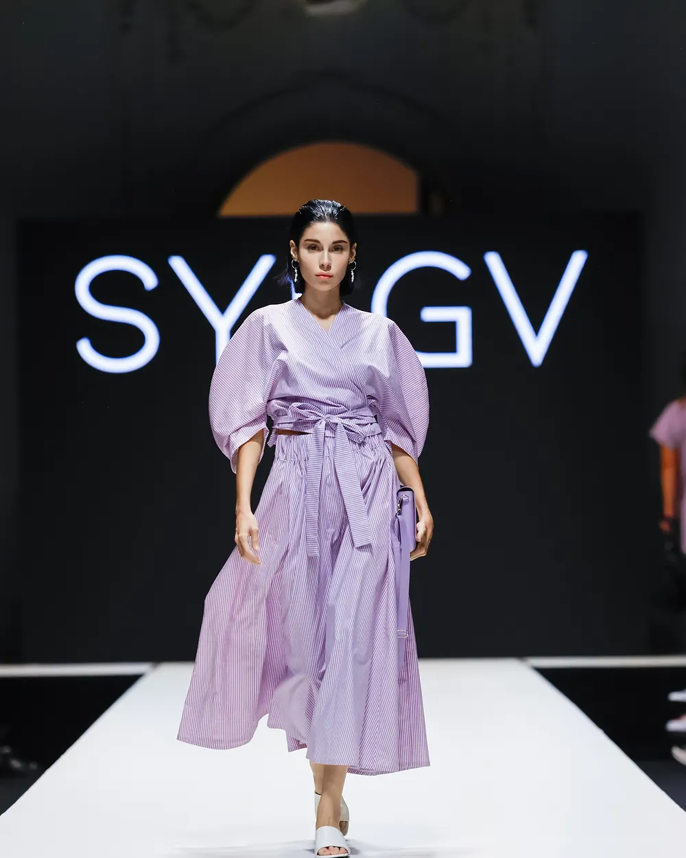 Model in fliederfarbenem Kleid mit voluminösen Ärmeln
