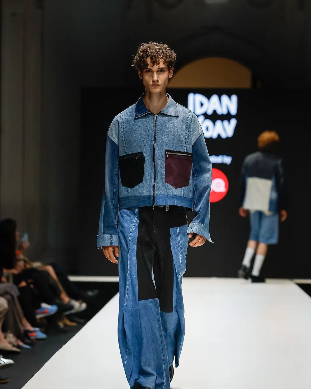 Model in einem aus verschiedenen Jeansstoffen zusammengesetzten Anzug