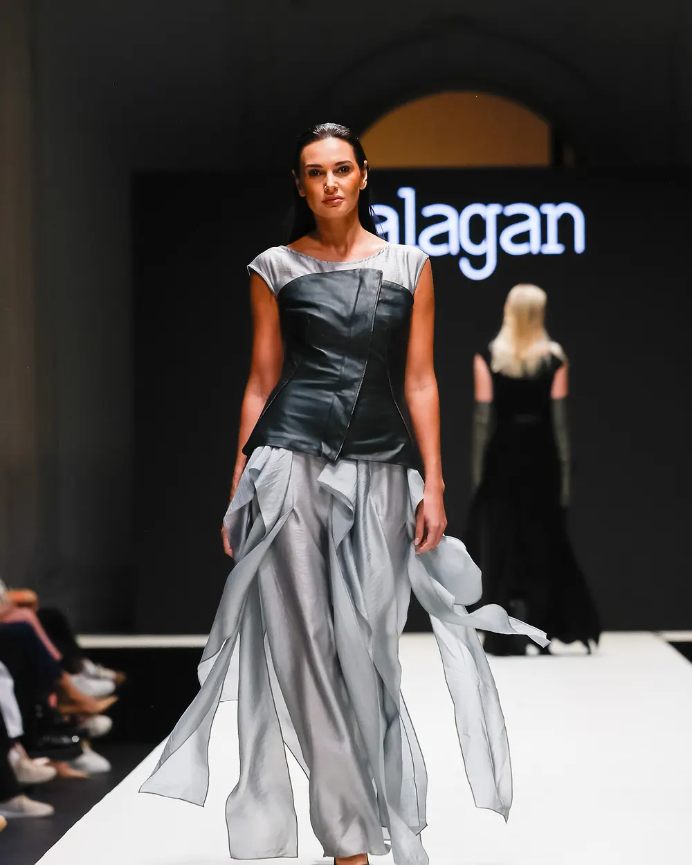 Model in silbergrauem Kleid mit fließendem Rock