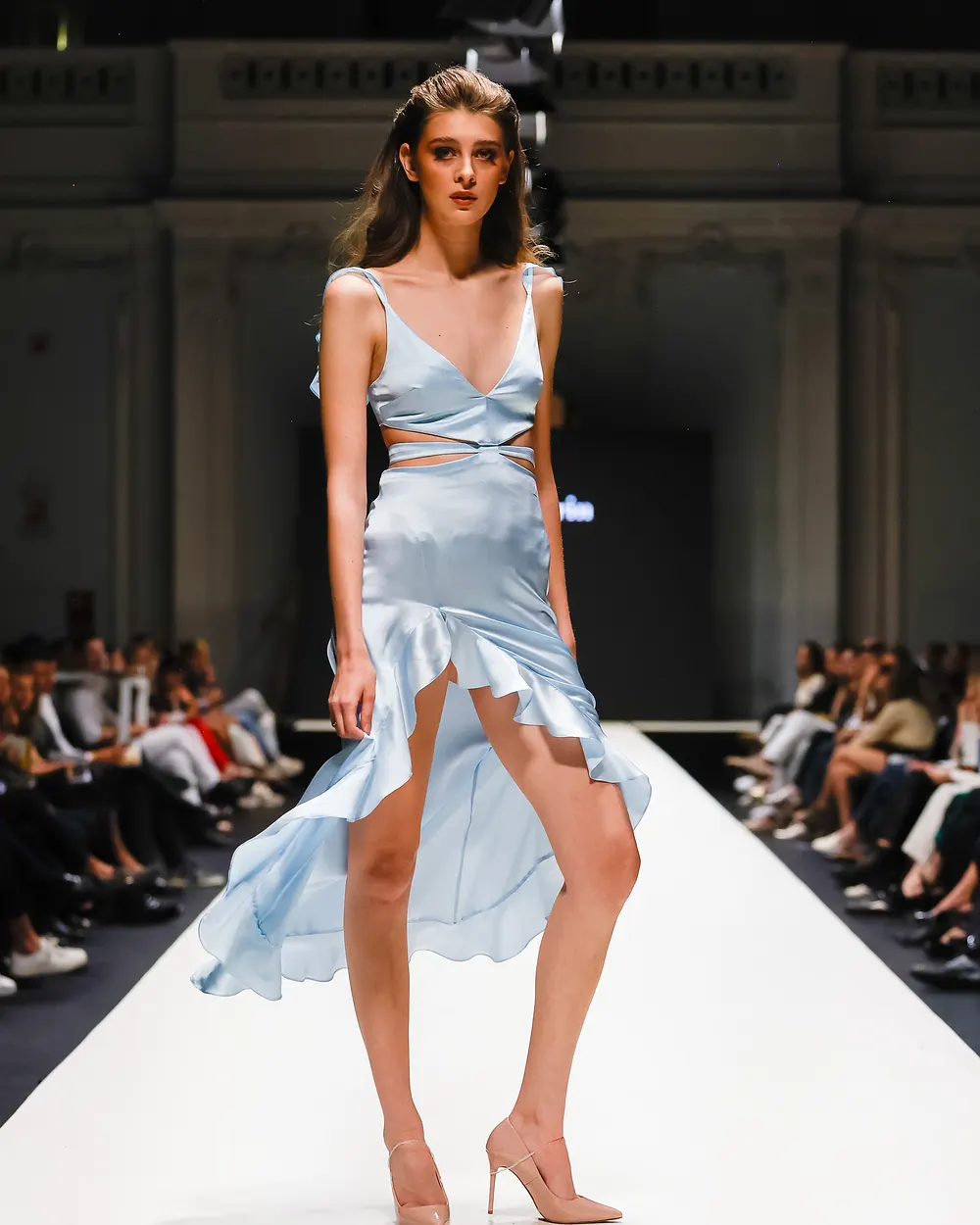 Model in hellblauem Satinkleid auf dem Laufsteg
