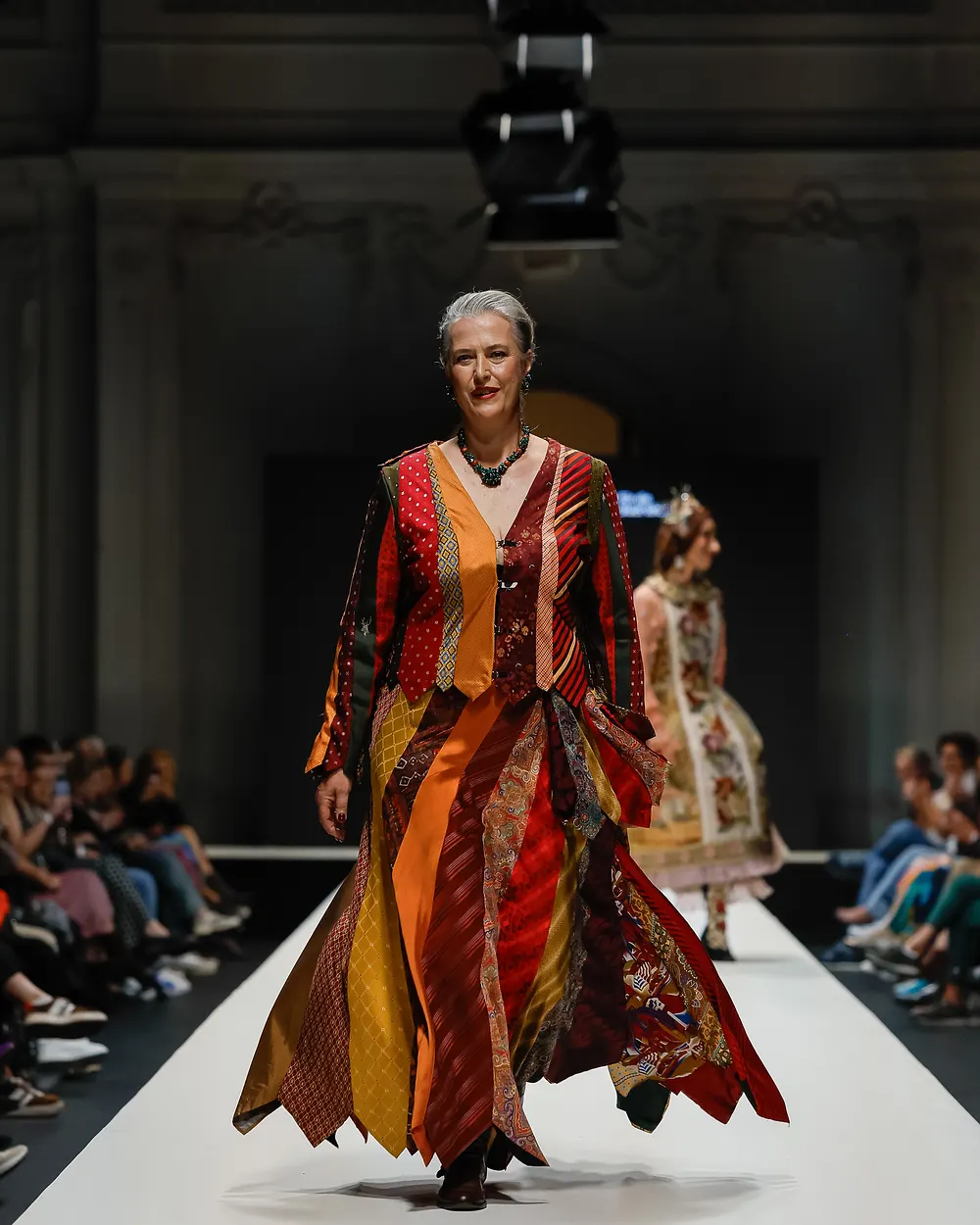Ältere Dame in gemustertem Mantelkleid auf dem Laufsteg von Fashion Reloaded
