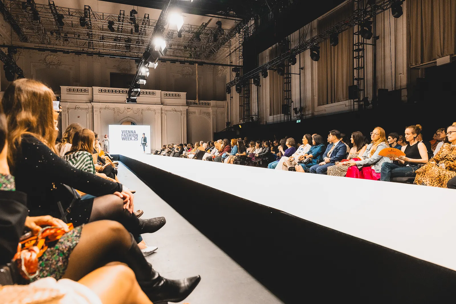 Blick über den weißen Laufsteg der Vienna Fashion Week, links und rechts das Publikum